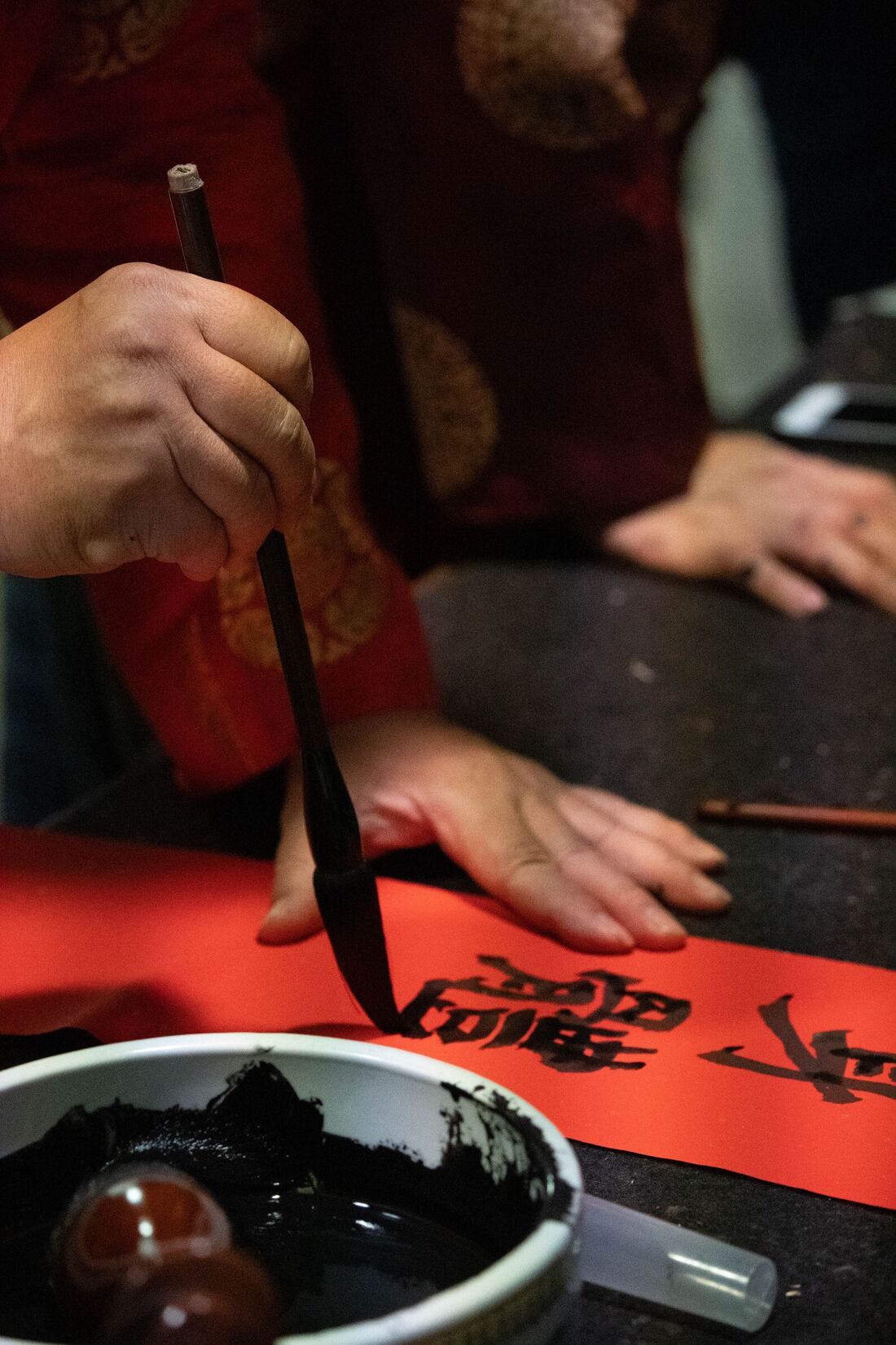 海外华裔孩子在中文学校执笔书写红纸，学习中文与中华文化